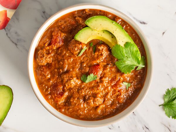 True Primal Beef Chili in bowl with avocado slices