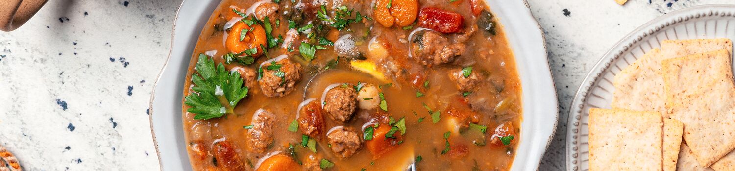 True Primal Hearty Beef Organic Soup in bowl next to crackers