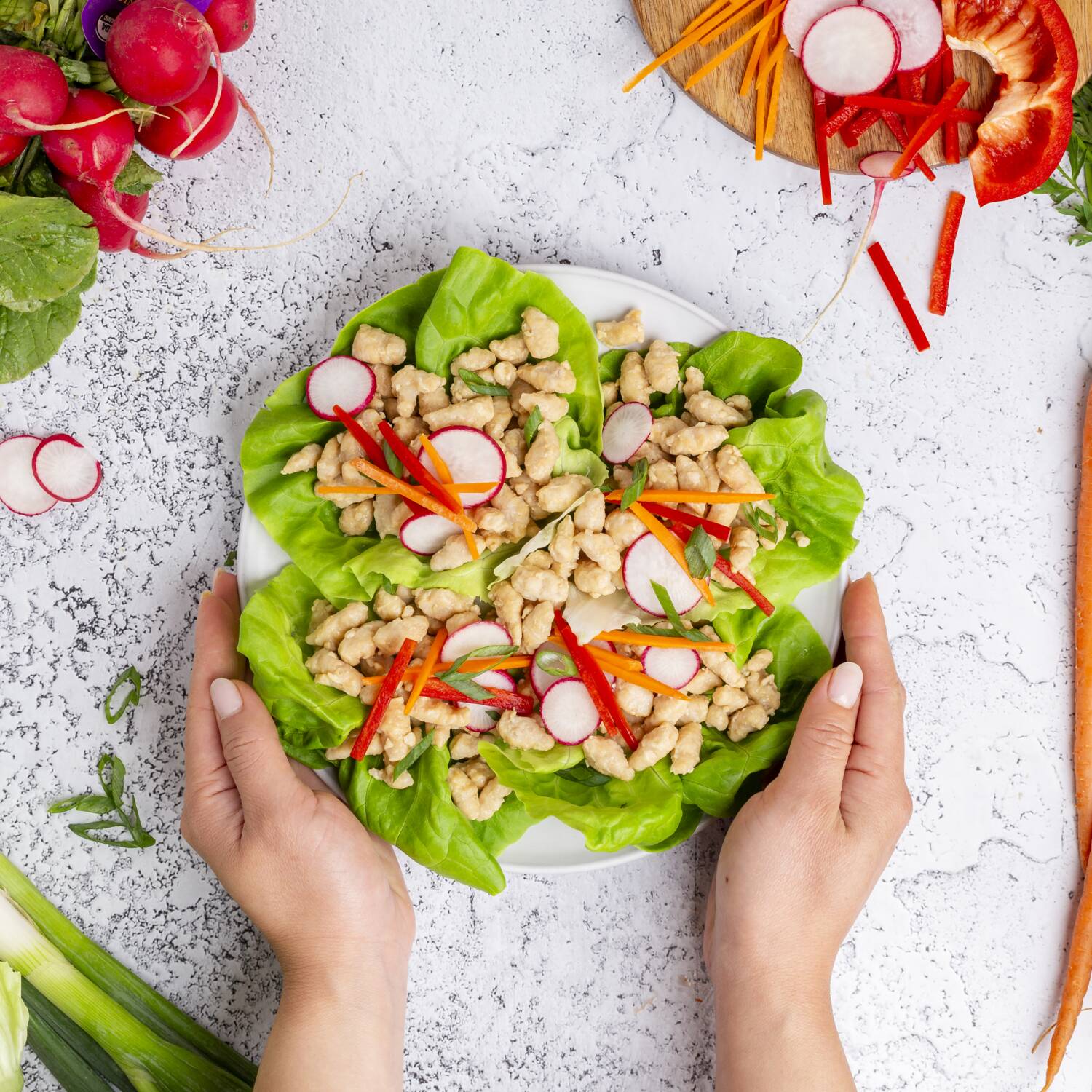 True Primal Pastured Chicken Mini Meatballs in lettuce wraps held on a plate