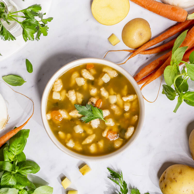Tuscan Style Chicken Soup in bowl surrounded by ingredients