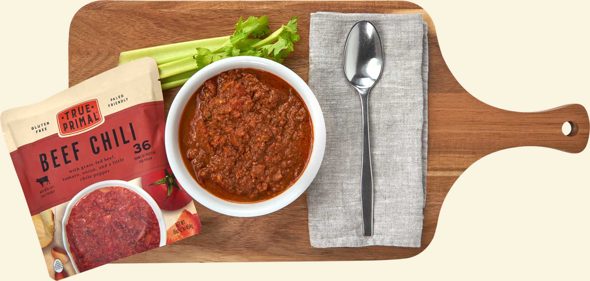 True Primal Beef Chili on cutting board with spoon