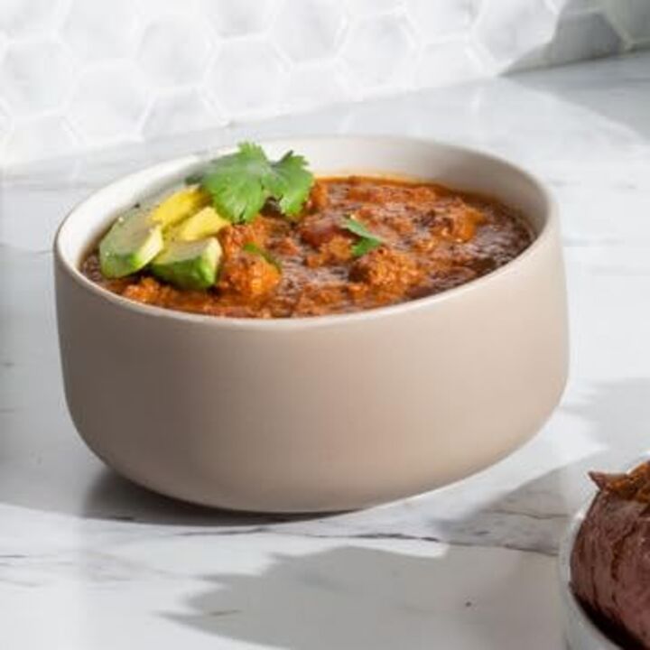 beef chili in bowl with avocado garnish
