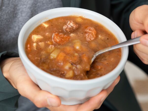 bowl of soup held in hand with spoon