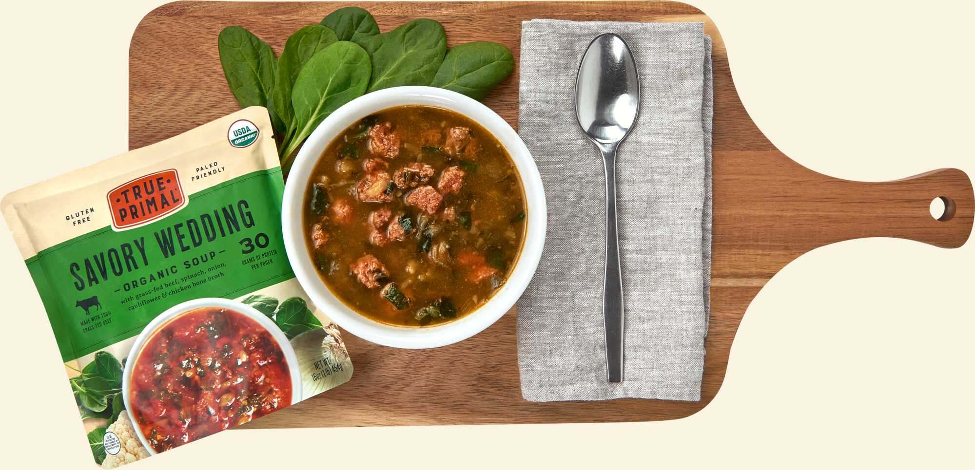 True Primal Savory Wedding Organic Soup on cutting board with spoon