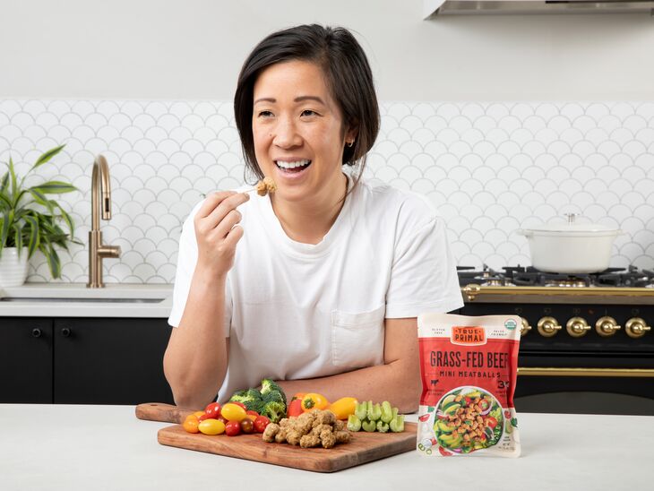 woman eating snack platter with vegetables and True Primal Grass-Fed Beef Mini Meatballs