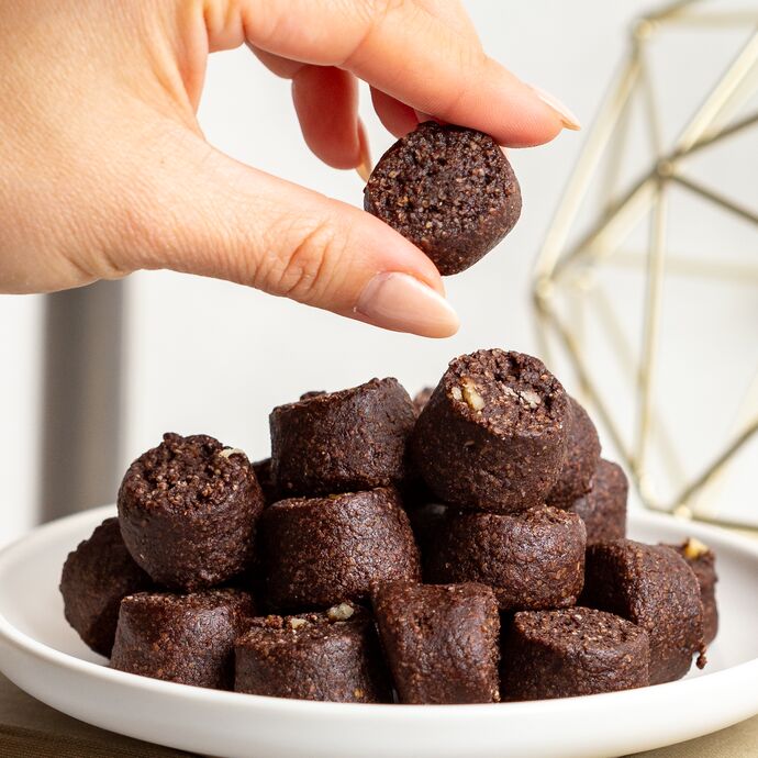 Ona Brownie Style Cookies on a plate with one being picked up