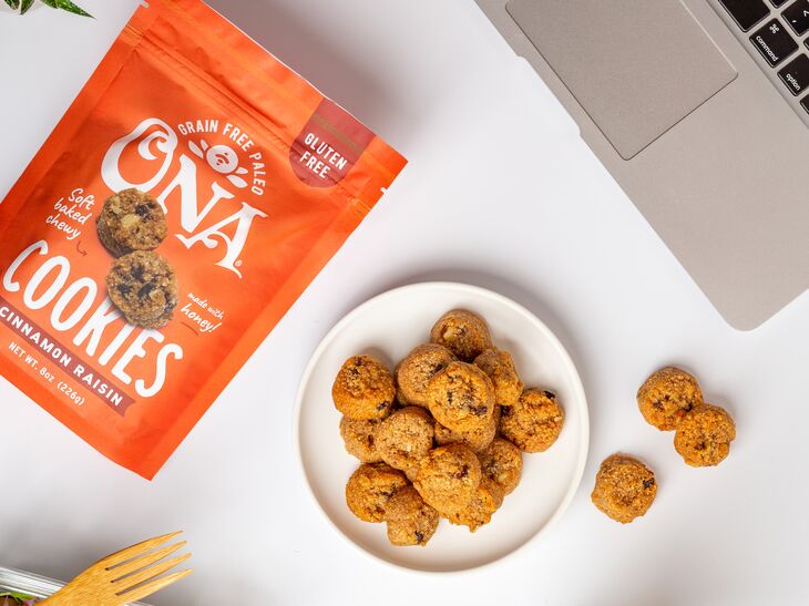 Ona Cinnamon Raisin Cookies in a pouch and on a plate near a salad