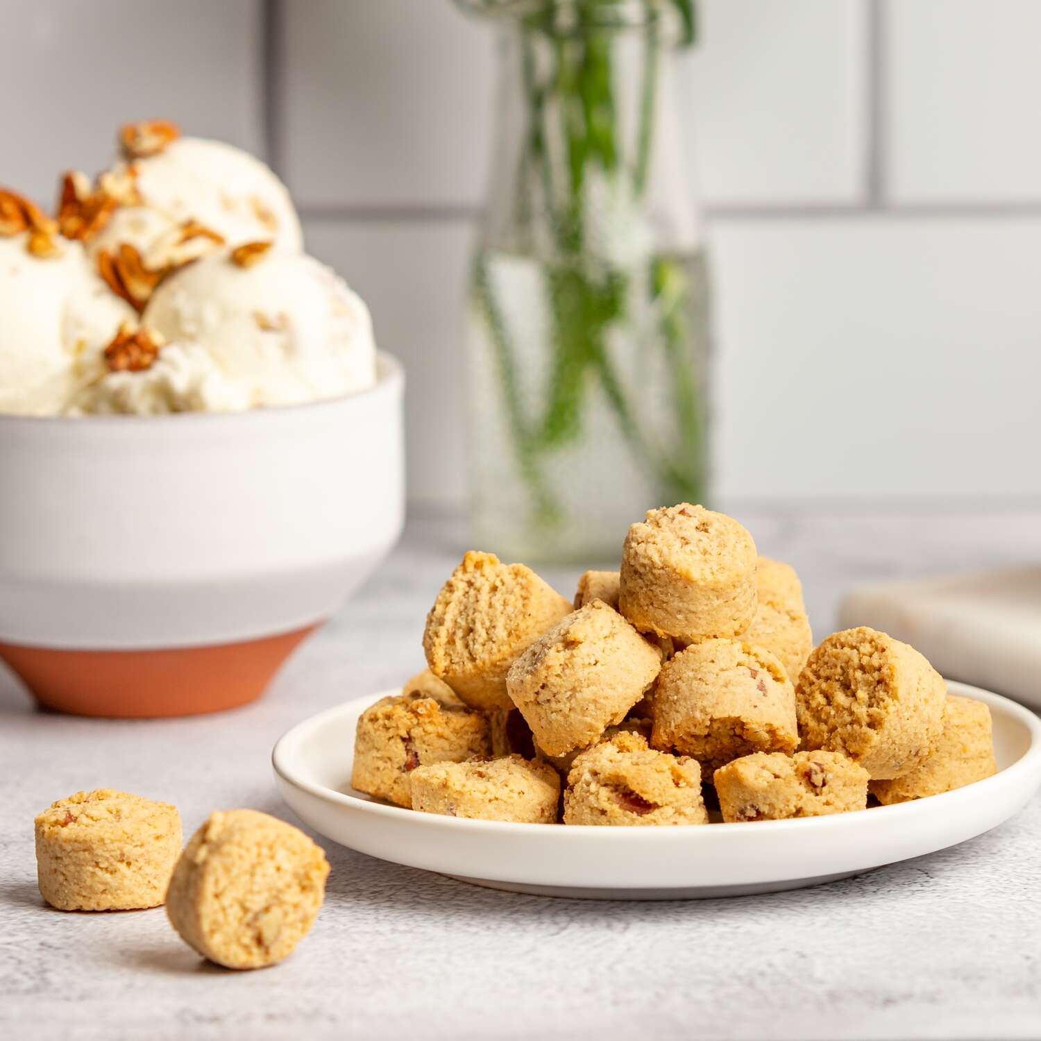 Ona Maple Pecan Cookies on a plate next to a bowl of ice cream