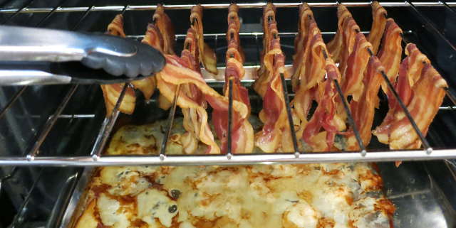 removing bacon from oven rack with tongs